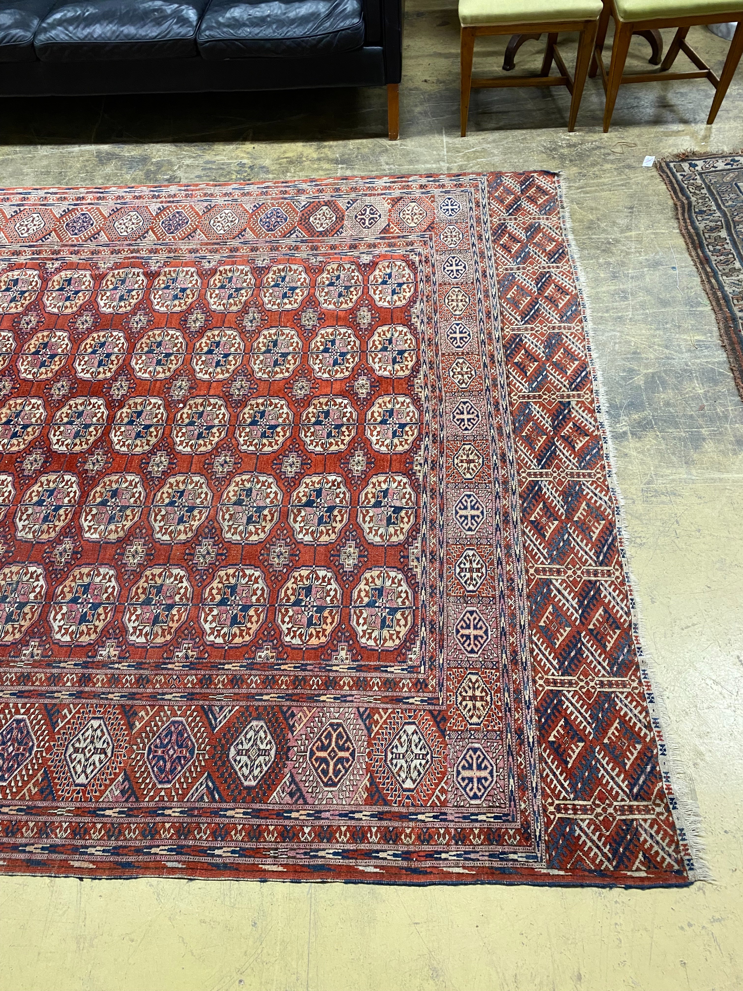 A Bokhara brick red ground carpet, 350 x 230cm